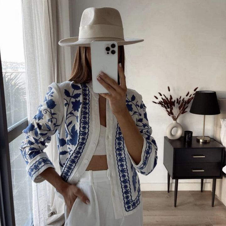 Damesblouse met blauw borduurpatroon, knoopsluiting en wijde manchetten