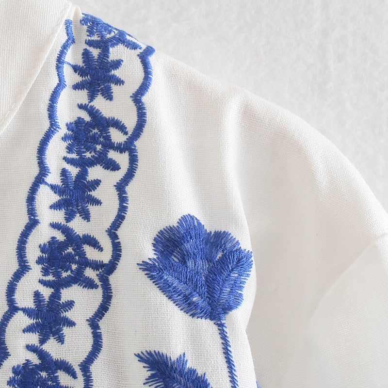 Damesblouse met blauw borduurpatroon, knoopsluiting en wijde manchetten