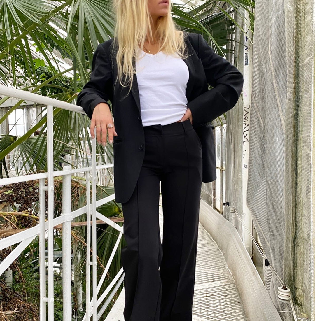 Damesbroek met hoge taille, wijde pijpen en zichtbare naden aan de voorkant