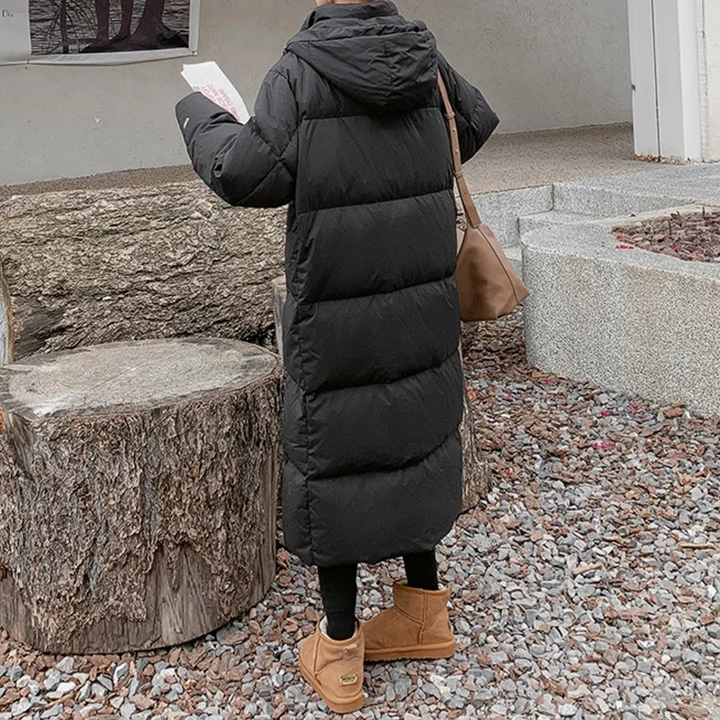 Dames lange gewatteerde pufferjas met capuchon, ritssluiting aan de voorkant en zijzakken
