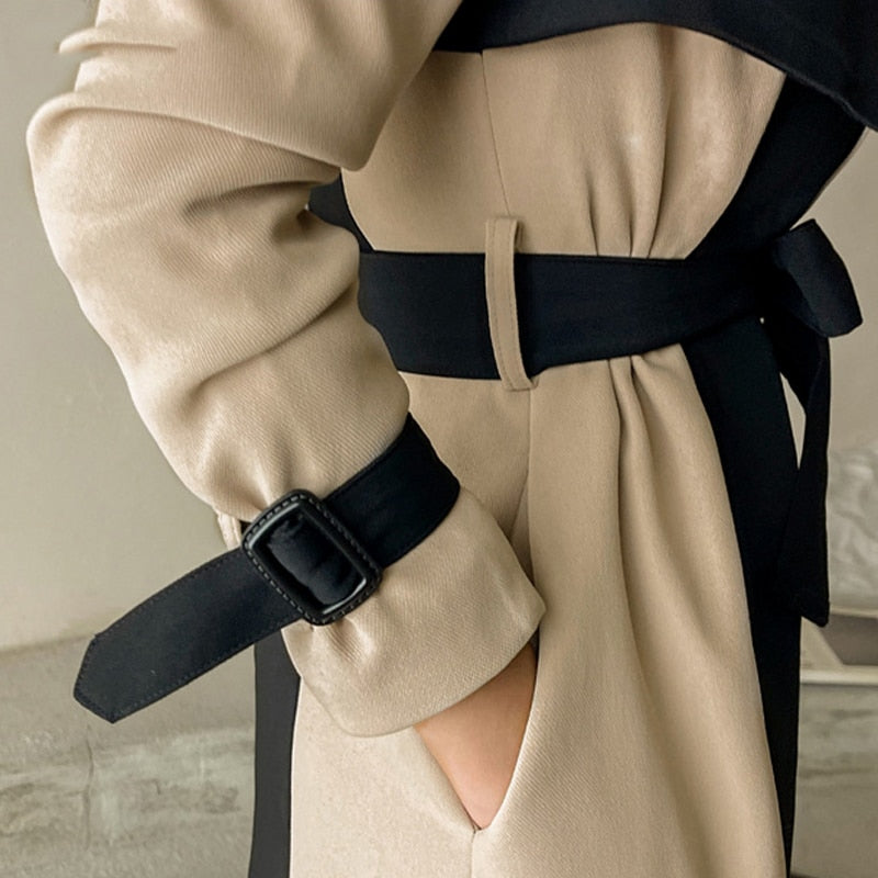 Dames lange jas met tweekleurige colour block en reverskraag met strikceintuur