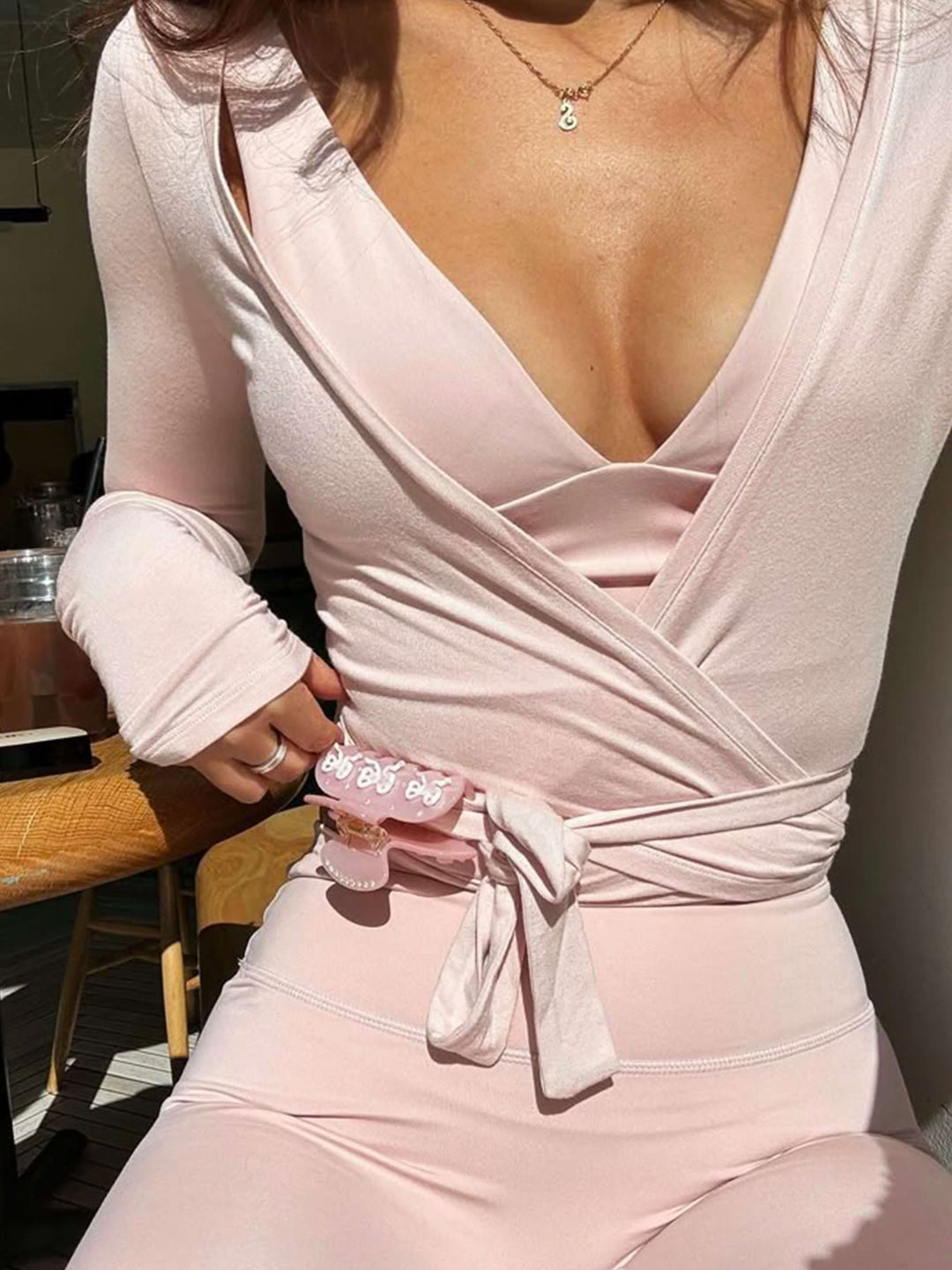 Dames wikkeltop met V-hals, lange mouwen en strikceintuur in de taille