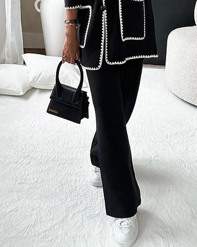 Dames tweedelige set met jasje met knopen, contrasterende bies, opgestikte zakken en wijde pijpen