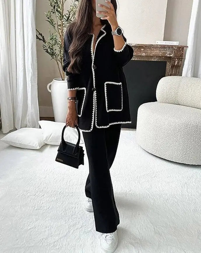 Dames tweedelige set met jasje met knopen, contrasterende bies, opgestikte zakken en wijde pijpen